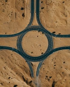 Top view of a desert roundabout surrounded by sand and roads.